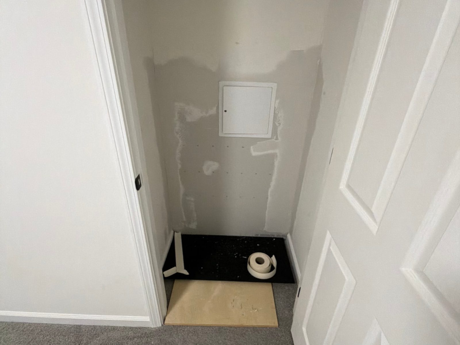 Closet wall with new access panel installed and drywall patched before finishing