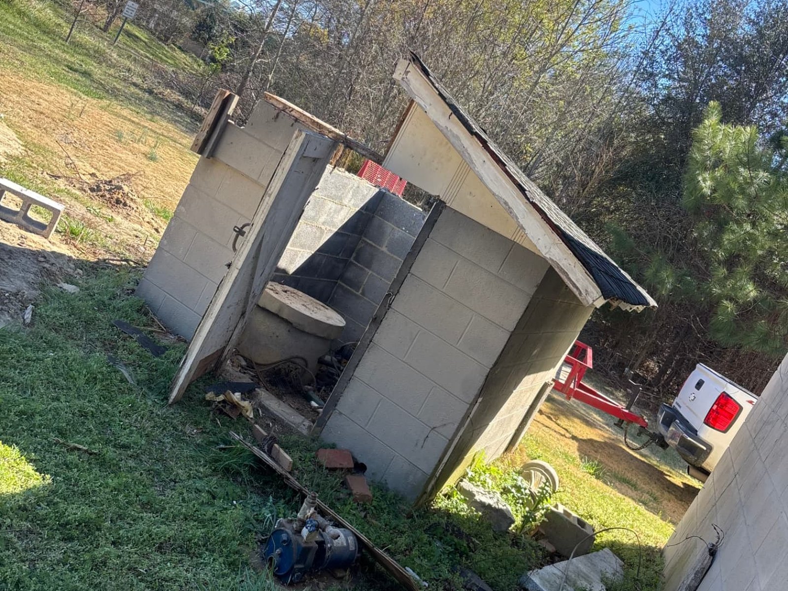 Collapsed cinder block shed with failing roof before demolition